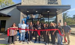 Troup Family Dental staff, community members and representatives of the Troup Chamber of Commerce gather for a ribbon-cutting during the dental practice's grand reopening celebration.